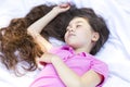 Adorable Little Girl With Extra Long Hair Lying On Sheet, White Linen, Sleeping. Caucasian Royalty Free Stock Photo