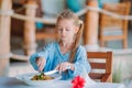 Adorable little girl having dinner at outdoor cafe Royalty Free Stock Photo