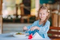 Adorable little girl having dinner at outdoor cafe Royalty Free Stock Photo