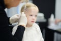 Adorable little girl having ear piercing process in beauty center Royalty Free Stock Photo