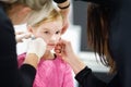 Adorable little girl having ear piercing process in beauty center Royalty Free Stock Photo
