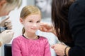 Adorable little girl having ear piercing process in beauty center Royalty Free Stock Photo