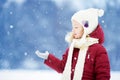 Adorable little girl having fun in beautiful winter park. Cute child playing in a snow. Royalty Free Stock Photo