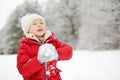 Adorable little girl having fun in beautiful winter park. Cute child playing in a snow. Royalty Free Stock Photo