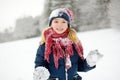 Adorable little girl having fun in beautiful winter park. Cute child playing in a snow. Royalty Free Stock Photo