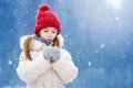 Adorable little girl having fun in beautiful winter park. Cute child playing in a snow. Royalty Free Stock Photo