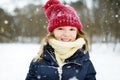 Adorable little girl having fun in beautiful winter park. Cute child playing in a snow. Royalty Free Stock Photo