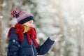 Adorable little girl having fun in beautiful winter park. Cute child playing in a snow. Royalty Free Stock Photo