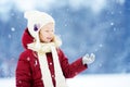 Adorable little girl having fun in beautiful winter park. Cute child playing in a snow. Royalty Free Stock Photo