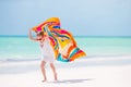 Adorable little girl having fun running with pareo on tropical white beach