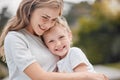 Adorable little girl and her mother sharing a hug and bonding outdoors at the park with nature background. Beautiful Royalty Free Stock Photo