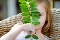 Adorable little girl hiding behind a leaf Royalty Free Stock Photo