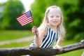 Adorable little girl holding american flag outdoors on beautiful summer day Royalty Free Stock Photo