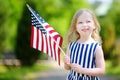 Adorable little girl holding american flag outdoors on beautiful summer day Royalty Free Stock Photo