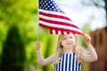 Adorable little girl holding american flag outdoors on beautiful summer day Royalty Free Stock Photo