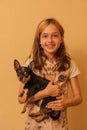 Adorable little girl holding chihuahua puppy standing. girl holding chihuahua dogs in her arms. girl 9 or 10 years