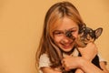 Adorable little girl holding chihuahua puppy standing. girl holding chihuahua dogs in her arms. girl 9 or 10 years