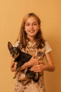 Adorable little girl holding chihuahua puppy standing. girl holding chihuahua dogs in her arms. girl 9 or 10 years