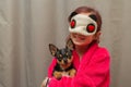 Adorable little girl holding chihuahua puppy standing and looking up