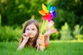 Adorable little girl holding colorful toy pinwheel on sunny summer day Royalty Free Stock Photo