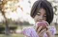 An adorable little girl holding red fresh apple