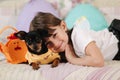 Adorable little girl hug her pet at home on sofa. Kid preparing for easter at home during quarantine. Cute dog Royalty Free Stock Photo