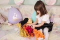 Adorable little girl hug her pet at home on sofa. Kid preparing for easter at home during quarantine. Cute dog Royalty Free Stock Photo