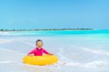 Adorable little girl with inflatable rubber circle splashing. Kid having fun on summer active vacation