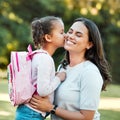 Adorable little girl kissing her mother on the cheek outside. Cute mixed race child saying goodbye to parent outside Royalty Free Stock Photo