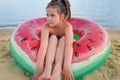 Adorable little girl with large inflatable rubber circle during beach vacation