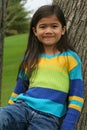 Adorable little girl leaning up against tree Royalty Free Stock Photo