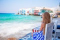 Adorable little girl at Little Venice the most popular tourist area on Mykonos island, Greece. Beautiful kid smile and Royalty Free Stock Photo