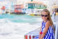 Adorable little girl at Little Venice the most popular tourist area on Mykonos island, Greece. Beautiful kid smile and Royalty Free Stock Photo