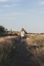 Adorable little girl running down the hill back view. Happy child running in wild grass countryside landscape Royalty Free Stock Photo