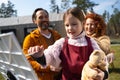 Adorable little girl painting picture with parents outdoors