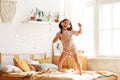 Adorable little girl in pajama preschool child holding hair brush as microphone and singing while standing on the bed Royalty Free Stock Photo