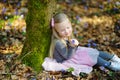 Adorable little girl picking the first flowers of spring in the woods on beautiful sunny spring day Royalty Free Stock Photo