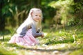 Adorable little girl picking the first flowers of spring in the woods on beautiful sunny spring day Royalty Free Stock Photo