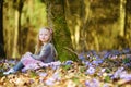 Adorable little girl picking the first flowers of spring in the woods on beautiful sunny spring day Royalty Free Stock Photo