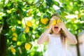 Adorable little girl picking fresh ripe lemons