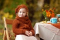 Adorable little girl on picnic in autumn park. Cute little girl having tea party outside in the autumn garden. Happy childhood