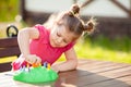 Adorable little girl playing board game outdoors