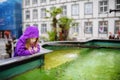 Adorable little girl playing by a fountain in Lindau, Germany