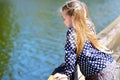 Adorable little girl playing by a river in sunny park Royalty Free Stock Photo