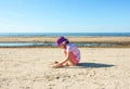 Adorable little girl playing with sand on the beach of Baltic sea. Royalty Free Stock Photo