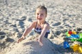 Adorable little girl playing with sand at the beach in summer Royalty Free Stock Photo