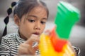 Adorable little girl playing toy blocks in a bright room