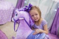 Adorable little girl playing with a toy horse at Royalty Free Stock Photo