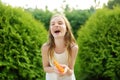 Adorable little girl playing with water gun on hot summer day. Cute child having fun with water outdoors Royalty Free Stock Photo