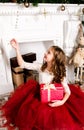 Adorable little girl in princess dress with gift box near firep Royalty Free Stock Photo